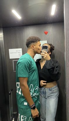 a man and woman taking a selfie in an elevator