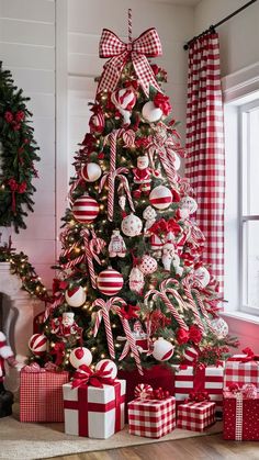 a christmas tree decorated with red and white striped bows, ornaments and candy canes