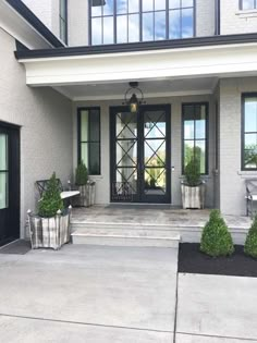 the front entrance of a house with potted plants