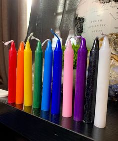 several different colored crayons are lined up on a shelf next to a globe