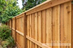 a wooden fence in front of some trees