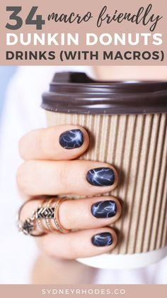 a woman's hand holding a coffee cup with blue marbled nails