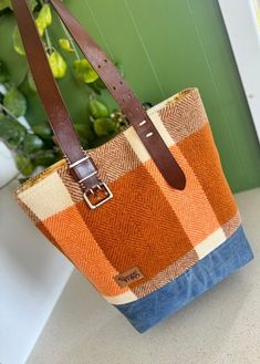 a brown and blue bag sitting on top of a counter next to a plant in a pot