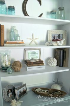 a shelf filled with books and pictures on top of it