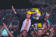 a man is in the middle of a crowd with his arms up and hands raised