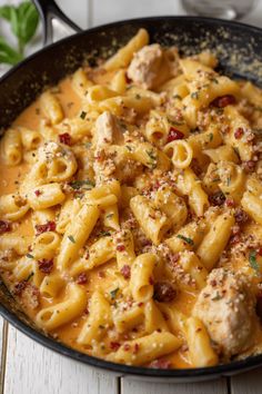 a skillet filled with pasta and meat covered in sauce