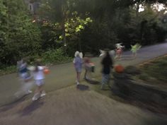 blurry image of people walking down the street at night time with one person holding an orange frisbee