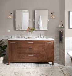 a bathroom with two sinks and mirrors on the wall