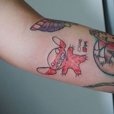 a person's arm with tattoos on it and an image of a cartoon character