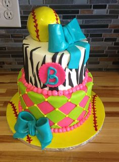 a birthday cake decorated with zebra print, baseballs, and bow on a wooden table