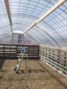 a ladder is standing in the middle of a building with a glass roof over it