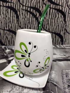 a green toothbrush holder sitting on top of a white plate next to a black and white wall