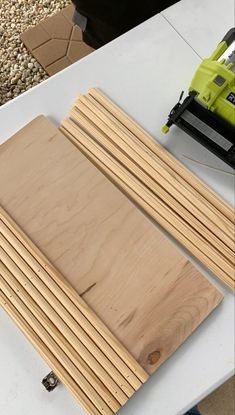 two pieces of plywood sitting on top of a white table next to a power drill