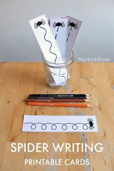 spider writing printable cards in a glass with pencils and markers on the table