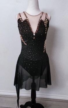 a mannequin wearing a black dress with gold sequins on the back