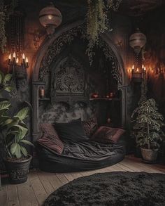 a bed with lots of plants and candles on it's headboard in a dark room