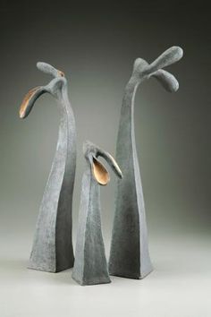 two sculptures made out of concrete are standing next to each other on a gray surface