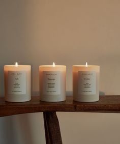 three candles sitting on top of a wooden table