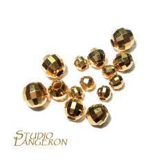 gold plated glass beads are arranged on a white background with the words studio dangeron above them