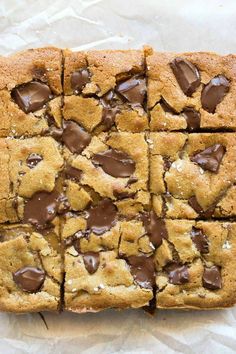 chocolate chip cookie bars cut into squares on wax paper