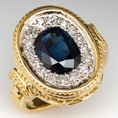 This stunning ring is decorated with engraved scroll and rope motifs and is centered with one (1), bezel set, oval mixed cut natural sapphire. The sapphire is bordered with sixteen (16), bead set, round single cut diamonds. The ring measures 16.8mm at the top, rises 4.3mm above the finger, tapering to 3.5mm wide and 1.8mm thick at the base of the shank. This ring is currently a size 3.5. Luxury Sapphire Ring With Intricate Design, Antique Oval Sapphire Ring For Formal Occasions, Exquisite Oval Sapphire Ring For Formal Occasions, Formal Sapphire Ring With Oval Accent Stones, Exquisite Oval Sapphire Ring With Diamond Accents, Luxury Oval Sapphire Ring With Bezel Setting, Luxury Sapphire Ring With Intricate Design For Formal Occasions, Oval Sapphire Ring With 17 Jewels For Anniversary, Luxury Oval Sapphire Ring For Anniversary