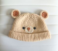 a crocheted bear hat is hanging on the wall