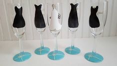 five wine glasses with black dresses on them