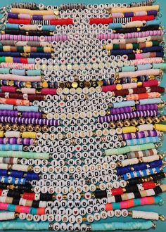 an assortment of beaded bracelets are displayed on a blue surface