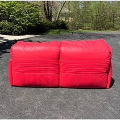 two red bags sitting on top of each other in the middle of a parking lot