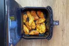 chicken wings in an air fryer on a wooden table