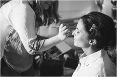 a woman getting her makeup done by another woman