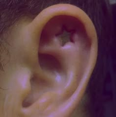 a close up of a person's ear with a star on it