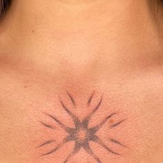 a woman's chest with an intricate tattoo design on the back of her neck