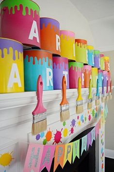 colorful paint buckets are hanging on the mantle