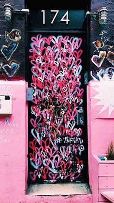 a pink door with lots of graffiti on it