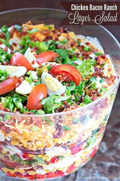 chicken bacon ranch layered salad in a glass bowl on a table with text overlay