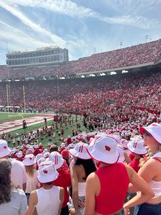 a football stadium filled with people wearing red and white hats