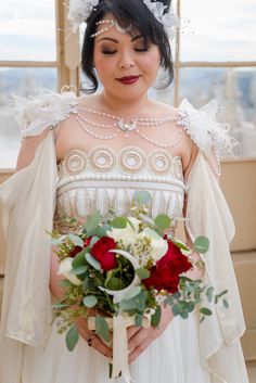 a woman in a wedding dress holding a bouquet and looking down at the camera with her eyes closed