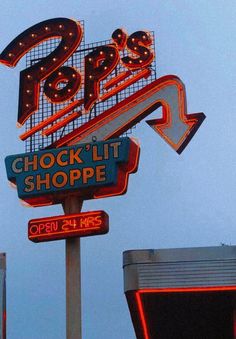 a neon sign for a grocery store with the word shop lit up on it's side