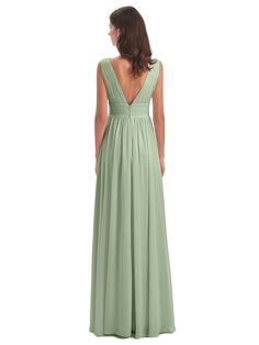 a woman in a long green dress looking back at the camera with her hands on her hips