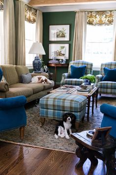 a living room filled with furniture and a dog sitting on the floor next to it