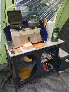 an open tent with several items on the table and in it's storage compartment