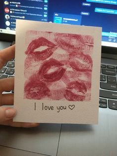 someone holding up a card that says i love you with lipstick drawn on the paper