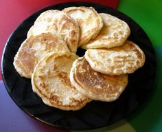 pancakes on a black plate sitting on a table