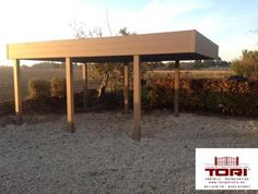 an outdoor covered area with gravel and bushes