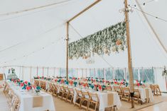 the inside of a large tent with tables and chairs set up for an outdoor event