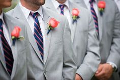 a group of men in suits with red roses on their lapels