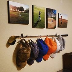 several pictures hang on the wall with hats and mitts hanging from it's hooks