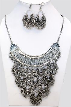 Intricately carved design, boho tribal style oxidized silver heavy and detailed choker style neck piece. It has a five tier design, a crescent shaped moon with 10 medallion shaped coins with hanging silver trinkets. It comes with a pair of matching earrings in the same shape as the medallions on the choker, with fish hook backs.. A lovely and very unique piece of jewelry to own and wear. It closes with a lobster clasp at the back. Bohemian Crescent Metal Necklaces, Bohemian Crescent Jewelry With Oxidized Finish, Bohemian Crescent Jewelry Oxidized Finish, Crescent Metal Jewelry For Festivals, Metal Crescent Jewelry For Festivals, Crescent-shaped Metal Jewelry For Festivals, Bohemian Crescent Metal Jewelry, Metal Crescent Shaped Festival Jewelry, Ornate Metal Chandbali Jewelry