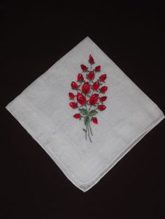 a white napkin with red flowers on it